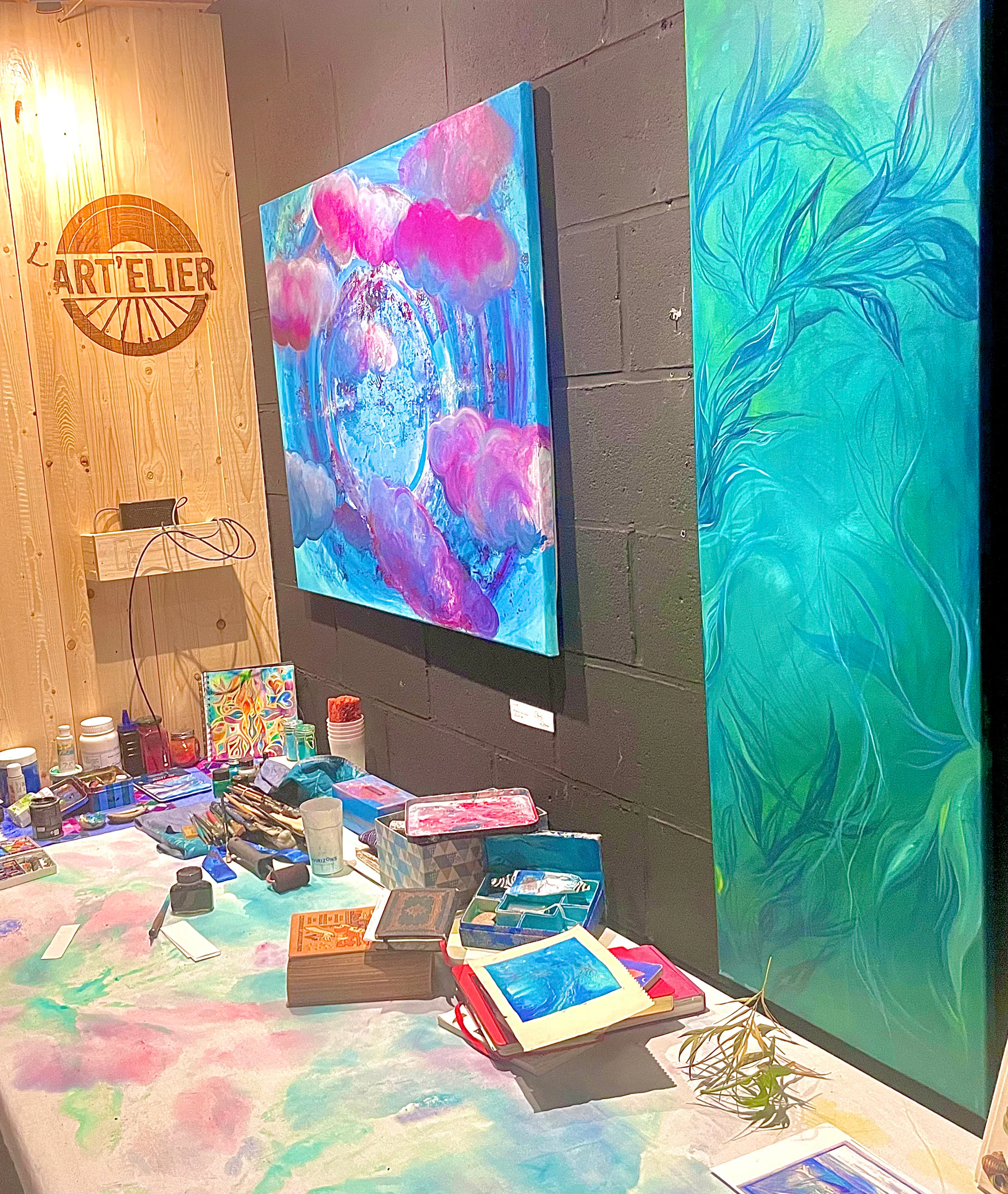 L'Art'elier, avec deux grandes toiles de Nina au mur et une table de peinture.